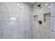 Modern shower with marble tile and built-in shelves at 50811 N 295Th Ave, Wickenburg, AZ 85390