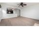 Bright living room featuring neutral carpeting and a view of the kitchen at 931 W Cedar Tree Dr, San Tan Valley, AZ 85143