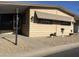 Tan mobile home exterior with small front porch, landscaping, and awning at 11411 N 91St Ave # 29, Peoria, AZ 85345