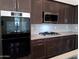 Modern kitchen features dark cabinetry, stainless steel appliances, and quartz countertops at 21018 E Calle Luna Ct, Queen Creek, AZ 85142