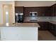 Modern kitchen featuring dark cabinetry and a large island at 21018 E Calle Luna Ct, Queen Creek, AZ 85142