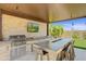 Outdoor kitchen with built in grill, fire pit, and bar seating at 26032 S 229Th Pl, Queen Creek, AZ 85142