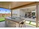 Covered outdoor kitchen and patio with view into the home's interior at 26032 S 229Th Pl, Queen Creek, AZ 85142