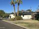 Exterior view of a home featuring a covered porch and landscaping with palm trees at 5217 N 18Th Pl, Phoenix, AZ 85016