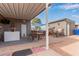 Covered patio with outdoor kitchen, seating area, and detached storage buildings at 5424 E Arbor Ave, Mesa, AZ 85206