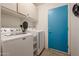 Bright laundry room with washer, dryer, and storage cabinets at 684 S 231St Dr, Buckeye, AZ 85326