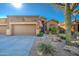 Tan stucco house with a two car garage and desert landscaping at 7143 E Canyon Wren Dr, Gold Canyon, AZ 85118