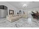 Spacious living room with a large sectional sofa, marble floors, and a grand chandelier at 7514 N 22Nd Pl, Phoenix, AZ 85020