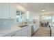 Modern kitchen featuring white cabinets, quartz countertops, and a gold faucet at 1017 W Whitton Ave, Phoenix, AZ 85013