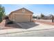 Two-car garage with tan exterior and gravel driveway at 15013 W Ventura St, Surprise, AZ 85379