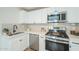 Renovated kitchen boasts modern white cabinets and stainless steel appliances at 1816 N 39Th Ave, Phoenix, AZ 85009