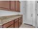 Laundry room with wood cabinets and granite countertop at 2008 E Stacey Rd, Gilbert, AZ 85298