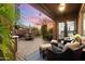 Covered patio with seating area, pavers, and lush landscaping overlooking the backyard at sunset at 2317 W Horsetail Trl, Phoenix, AZ 85085