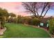 Lush green backyard with a curved artificial turf lawn, landscaping, and a sitting area at 2317 W Horsetail Trl, Phoenix, AZ 85085