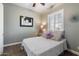 Cozy bedroom with patterned bedding, a window with plantation shutters, and artwork at 2317 W Horsetail Trl, Phoenix, AZ 85085