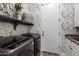 Laundry room with floral wallpaper, gray cabinets, and front-loading washer and dryer at 2317 W Horsetail Trl, Phoenix, AZ 85085