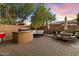 Spacious paver patio with built-in grill, seating, dining area, and umbrellas at 2317 W Horsetail Trl, Phoenix, AZ 85085