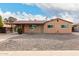 Tan single story house with carport, and rock landscaping at 2325 W Orchid Ln, Phoenix, AZ 85021