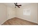 Bedroom with wood-look flooring, plantation shutters, a ceiling fan, and closet at 5812 E Grandview Rd, Scottsdale, AZ 85254