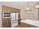 Kitchen with white appliances, wood cabinets, and island with white countertop at 5812 E Grandview Rd, Scottsdale, AZ 85254