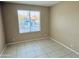 Well-lit bedroom with tile floors and a window at 6931 W Crittenden Ln, Phoenix, AZ 85033