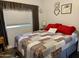 Comfortable bedroom with red and gray bedding, and a window with curtains at 7750 E Broadway Rd # 911, Mesa, AZ 85208