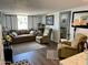 Living room with brown couch, recliner chairs, and large window at 7750 E Broadway Rd # 911, Mesa, AZ 85208