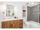 Modern bathroom with wood vanity, black and white striped shower, and bathtub at 8531 E San Miguel Ave, Scottsdale, AZ 85250