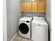 Laundry room with a stacked washer and dryer unit, and wooden cabinets overhead at 1351 N Pleasant Dr # 2079, Chandler, AZ 85225