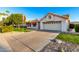 House exterior featuring a landscaped yard, American flag, and two-car garage at 14105 W Sky Hawk Dr, Sun City West, AZ 85375