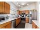 Modern kitchen with stainless steel appliances and wood cabinets at 16080 W Maricopa St, Goodyear, AZ 85338