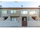 Front view of a two-story stucco townhome with a brown gate at 2040 S Longmore -- # 68, Mesa, AZ 85202