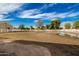 Fenced backyard with a small puddle, trees, and a house in the background at 21406 E Mewes N Rd, Queen Creek, AZ 85142