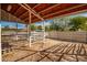 Covered barn or stable area with metal fencing and dirt floor at 21406 E Mewes N Rd, Queen Creek, AZ 85142