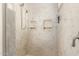 Close-up of shower stall with built-in shelves and marble-style tile at 21406 E Mewes N Rd, Queen Creek, AZ 85142