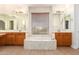 Large bathroom with double vanity, soaking tub, and window with blinds at 21406 E Mewes N Rd, Queen Creek, AZ 85142