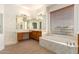 Spacious primary bathroom featuring double vanity, soaking tub, and wood-look flooring at 21406 E Mewes N Rd, Queen Creek, AZ 85142