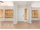 Bright foyer with a white front door, wood shutters, and wood-look flooring at 21406 E Mewes N Rd, Queen Creek, AZ 85142