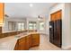 Kitchen with wood cabinets, a black refrigerator, and a view to the backyard at 21406 E Mewes N Rd, Queen Creek, AZ 85142
