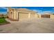 Tan three-car garage and driveway with a gated entry on the side at 21406 E Mewes N Rd, Queen Creek, AZ 85142