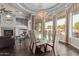 Elegant dining room with a glass table, unique chandelier, and pool views at 4599 N Village Pkwy, Litchfield Park, AZ 85340