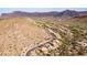 Aerial view of a home near a golf course nestled in the mountains at 5217 S Crested Saguaro Ln, Gold Canyon, AZ 85118