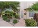 Front walkway to home entry lined with lush landscaping and palm trees at 7400 E Gainey Club Dr # 104, Scottsdale, AZ 85258