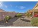 Landscaped backyard with gravel, plants, and a covered patio at 11335 W Madisen Ellise Dr, Surprise, AZ 85378