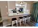 Kitchen breakfast bar with granite countertop and three white metal stools at 14821 N 51St Dr, Glendale, AZ 85306