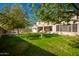 Green backyard, featuring a lawn, trees, and a stone birdbath at 15139 W Pierson St, Goodyear, AZ 85395