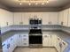 Modern kitchen with white cabinets, gray countertops, and stainless steel appliances at 22262 W Tonto St, Buckeye, AZ 85326