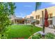 Artificial turf backyard with covered patio and mature plants at 8437 N 84Th Pl, Scottsdale, AZ 85258