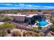 Aerial view of a home with a pool and expansive patio, surrounded by desert landscape at 9446 E Romping Rd, Carefree, AZ 85377
