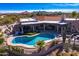 Aerial view of a home with a pool and desert landscaping; mountain views at 9446 E Romping Rd, Carefree, AZ 85377
